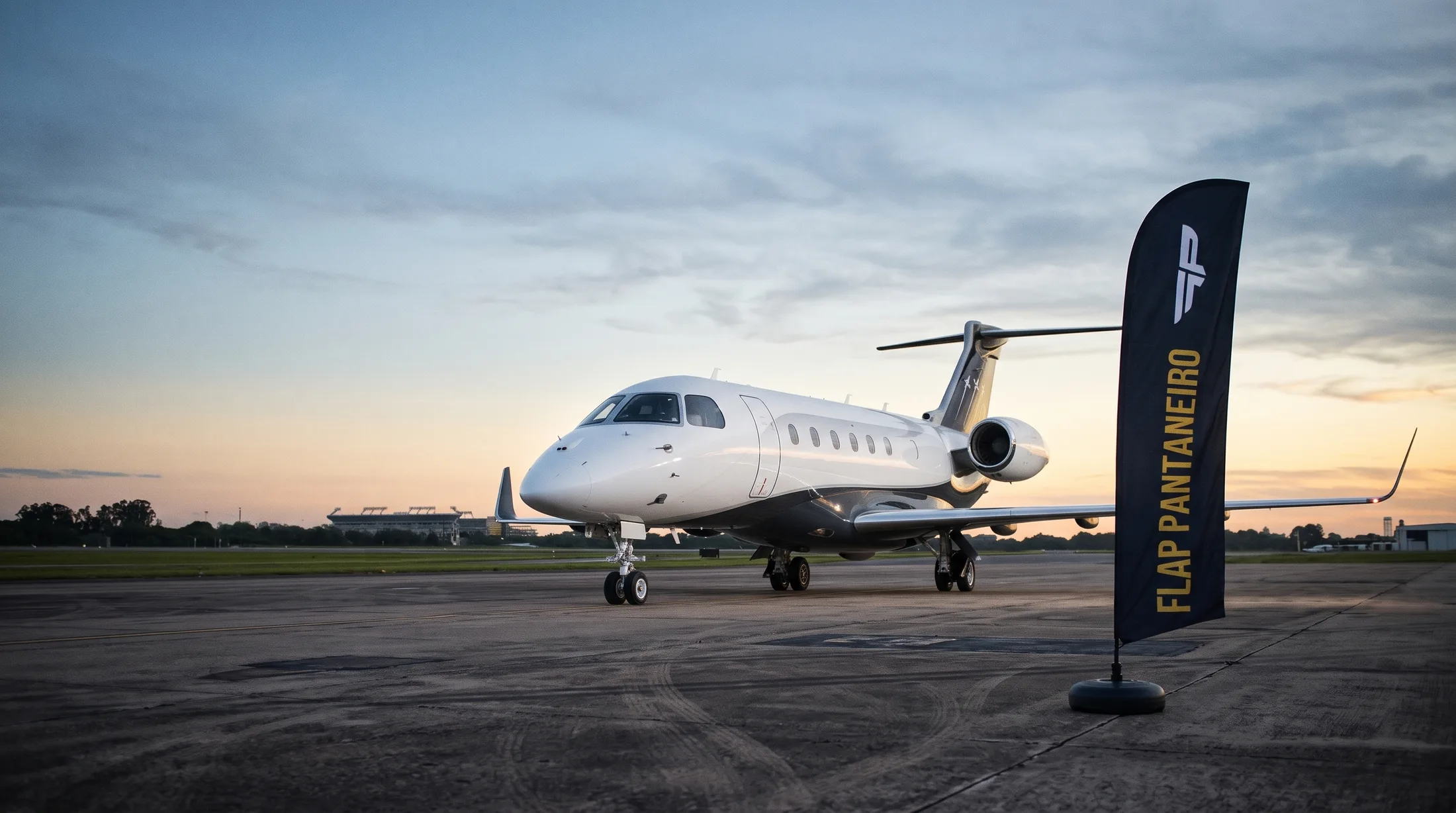 Jato executivo Embraer Praetor 600 estacionado no pátio, vista lateral pelo lado esquerdo.